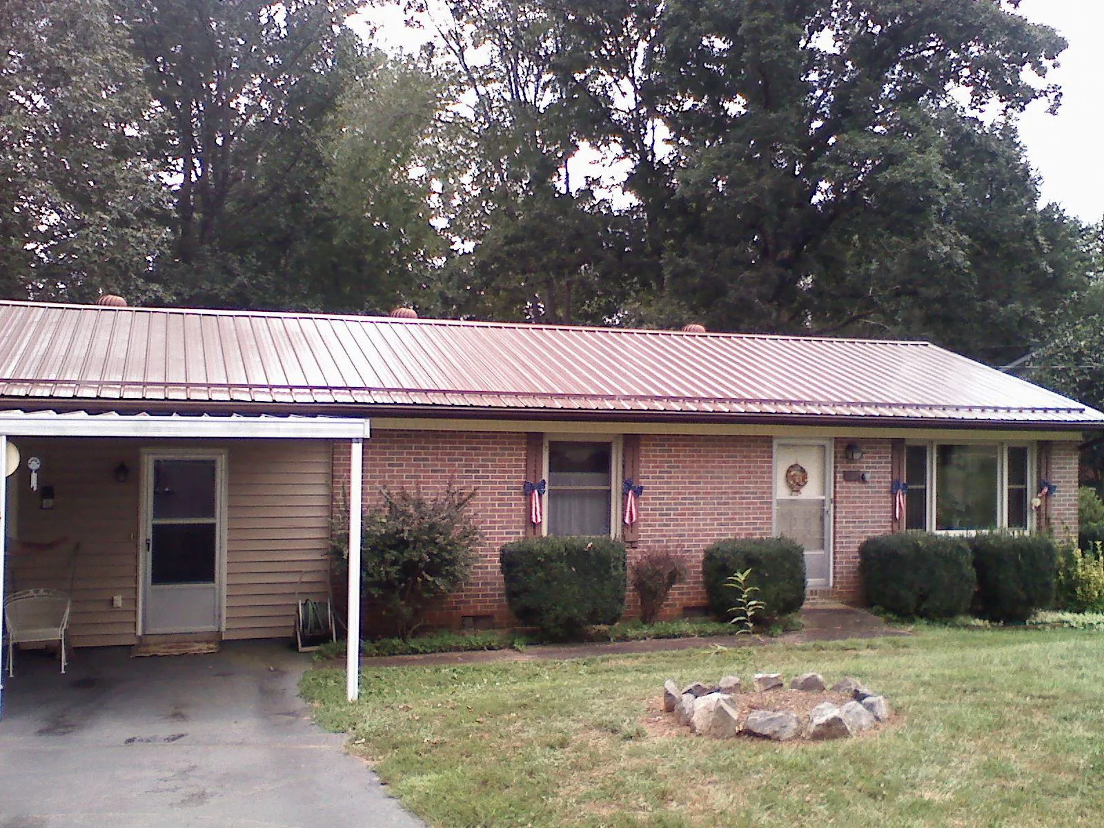 Bronze metal roof and carport on a brick ranch home — Roof Repair work by our crew in Carrolls
